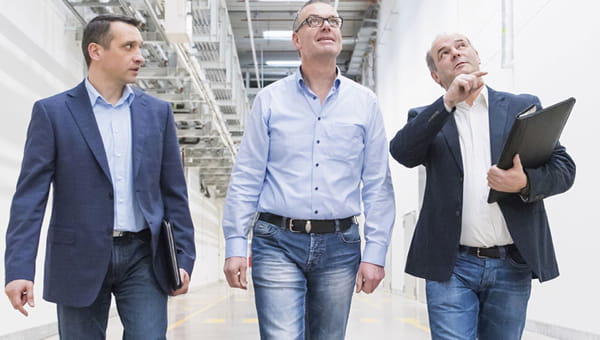 Drie mannen lopen door de gang